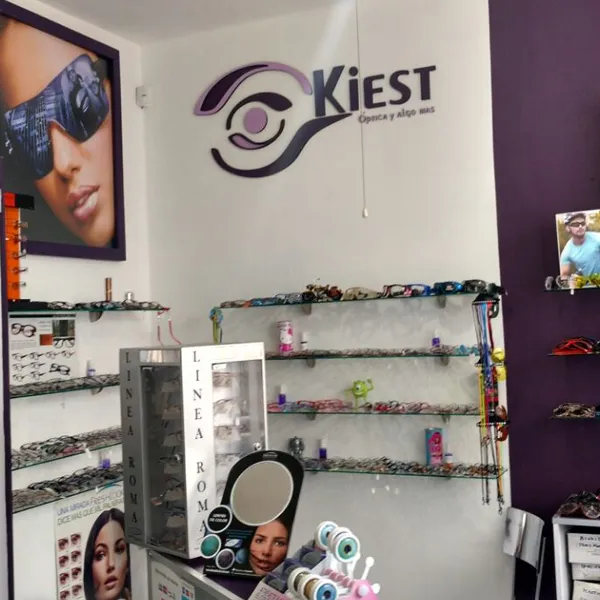 Óptica Kiest con logotipo en muro y exhibidores de armazones.