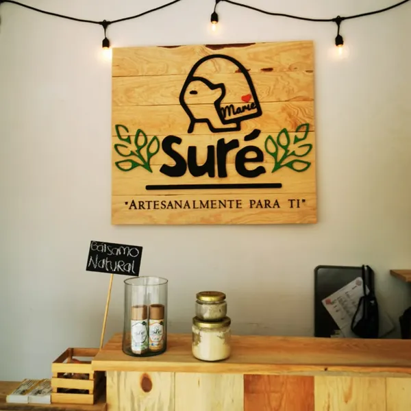 Letrero de madera de Suré con luces colgantes sobre barra de madera.